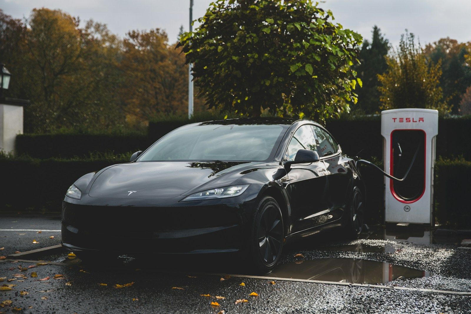 Electric sedan charging at a fast-charging station